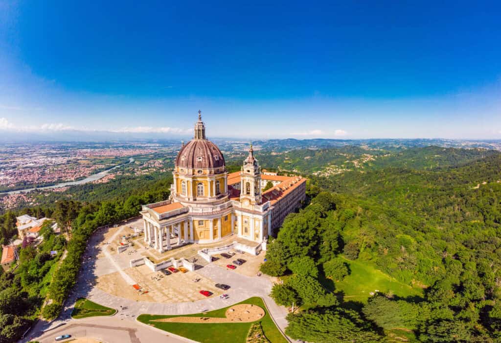 beautifull aerial panoramic view to the famous from the drone basilica of superga in sunny summer day. the cathedral church located at the top of hill in italian alps mountains. turin, piedmont, italy